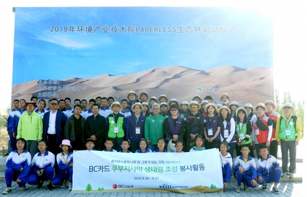 26일 중국 주요 황사 발원지 중 하나인 쿠부치 사막에서 BC카드 등 임직원 봉사자들과 현지 주민들이 조림사업 기념 단체사진을 촬영하고 있다. (사진= BC카드)