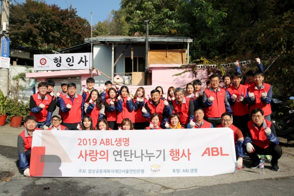 29일 ABL생명 직원 30여명이 서울 노원구 당고개역 부근에서 연탄 2000장을 홀몸 어르신이 거주하는 가구 13곳에 배달했다. 사진은 ABL관계자들이 기념촬영을 하는 모습.