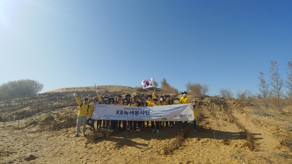 ‘KB녹색봉사단’이 중국의 대표 황사 발원지인 쿠부치 사막 등에서 환경보호 활동을 마친 후 기념촬영을 하고 있다.(사진=KB국민은행)