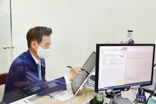 윤열현 교보생명 대표이사가 고객플라자 창구에서 전자문서 업무를 시연해보고 있다. (사진=교보생명)