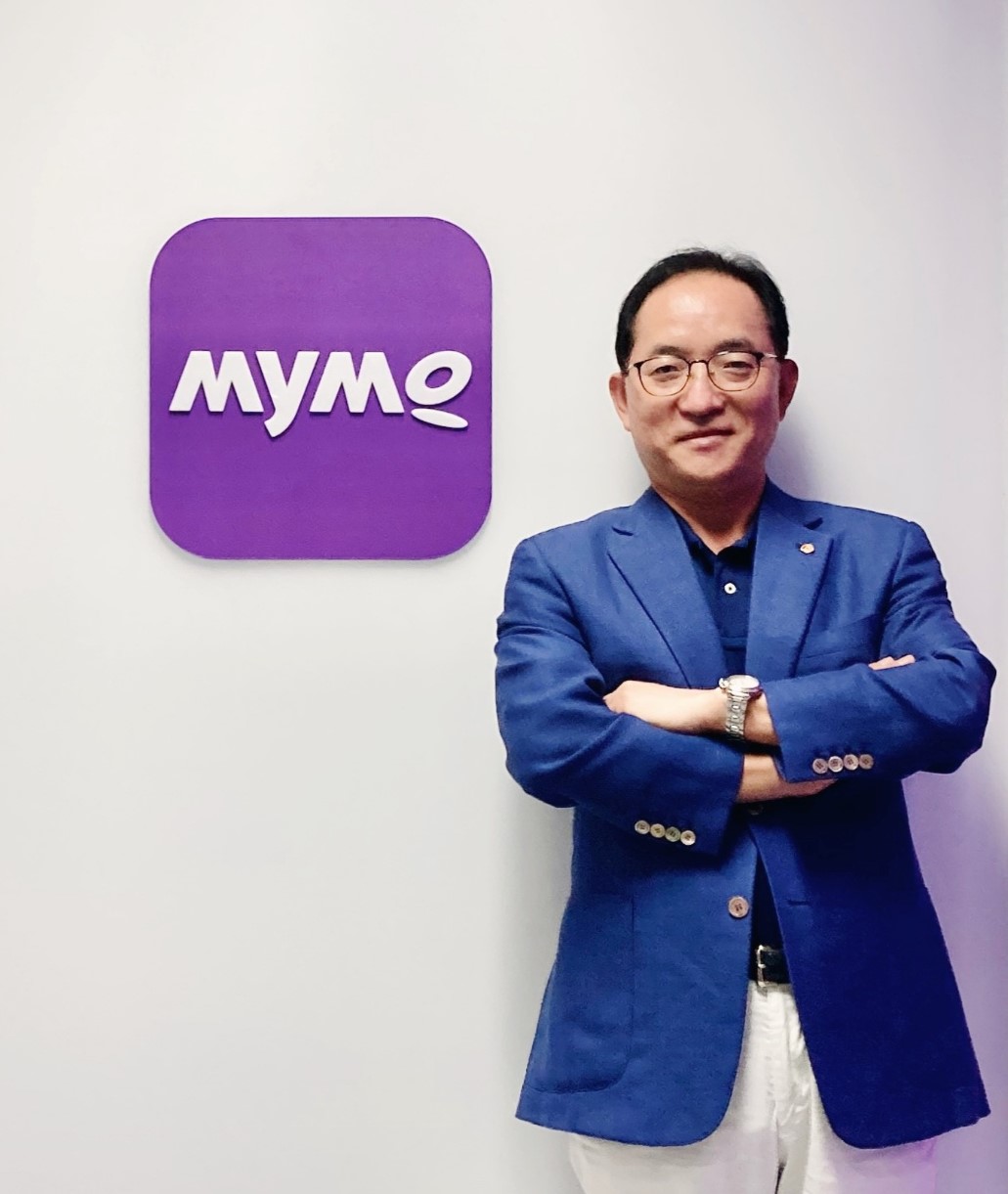  홍정표 한화저축은행 대표이사가 ‘Mymo(마이모)’ 앱 로고 앞에서 포즈를 취하고 있다.(사진=한화저축은행)