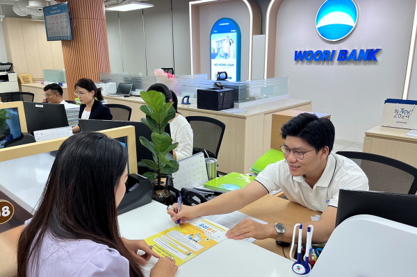 베트남우리은행 푸미흥 지점에서 직원이 내점 고객에게 우리루키 프로젝트 베트남 해외의료 지원사업에 대해 안내하고 있다.(사진=우리은행)