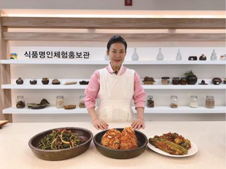 유정임 식품명인이 직접 시연한 포기김치, 열무김치, 오이소박이를 앞에 두고 포즈를 취하고 있다.