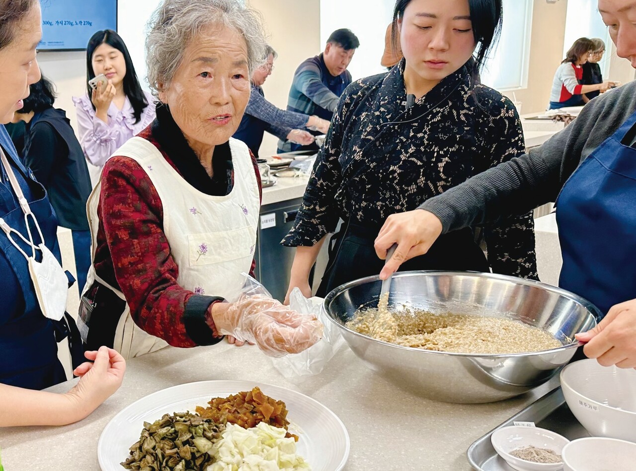 식품명인체험홍보관에서 진행된 즙장만들기 체험행사에서 백정자 명인이 체험객에게 직접 즙장에 관해 설명하고 있다.