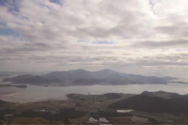 달마산 정상에 오르면 동서로 바다가 펼쳐진다. 윤슬이 가득한 바다에 무인도 하나가 갇혀있는 모습이다. (사진=김승호 편집위원)