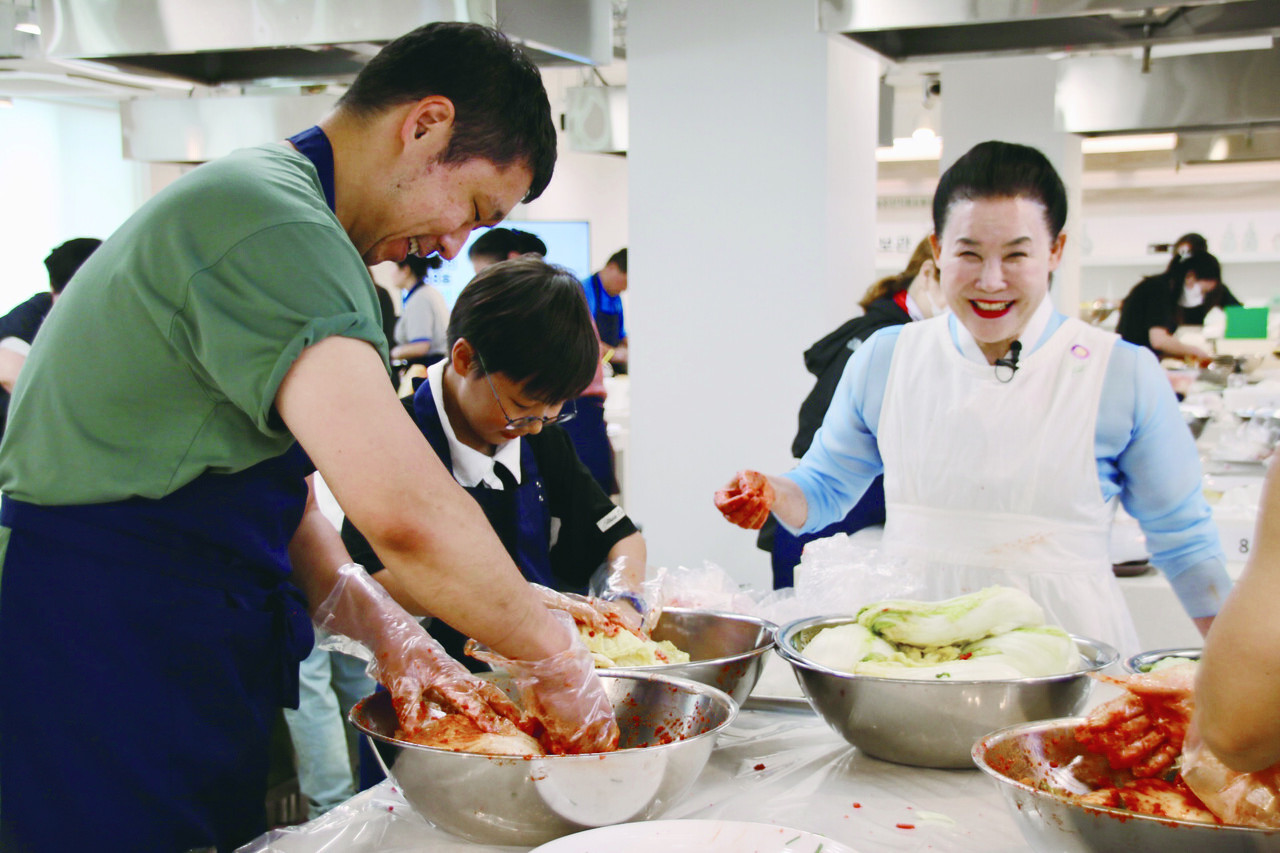 유정임 명인이 포기김치 체험행사에 참가한 가족 체험객에게 자신의 김치 담는 법을 설명하고 있다.
