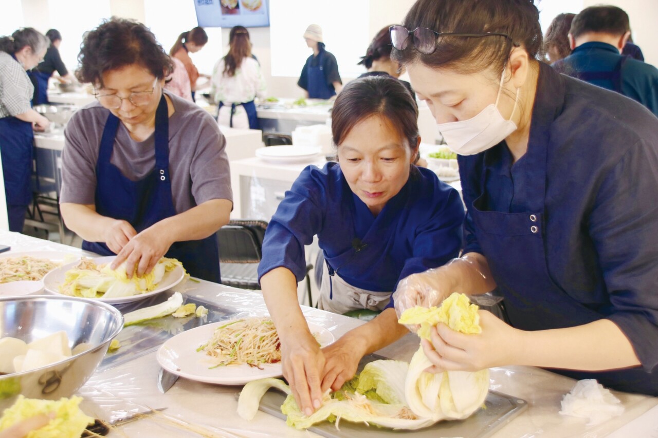반지 김치 윤다슬 전수자가 행사에 참여한 체험객에게 김칫소 넣는 방법을 일일이 설명하고 있다.