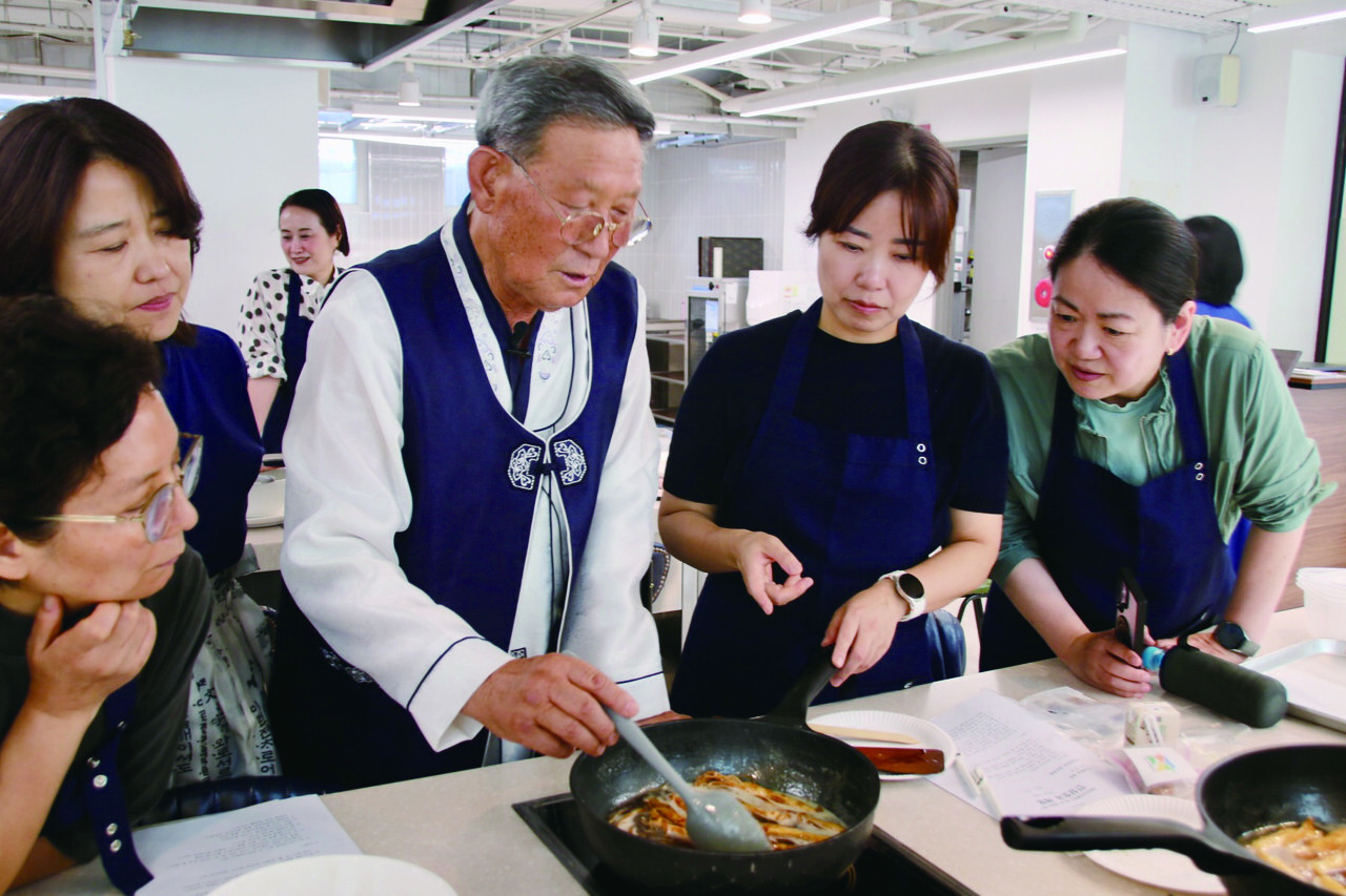 ▲ 정영석 식품명인이 체험객들에게 인삼정과 만드는 과정을 설명하고 있다. 조림방식으로 정과를 만들땐 불 앞을 떠나지 않고 두어 시간 이상 저어주며 조려야 한다.